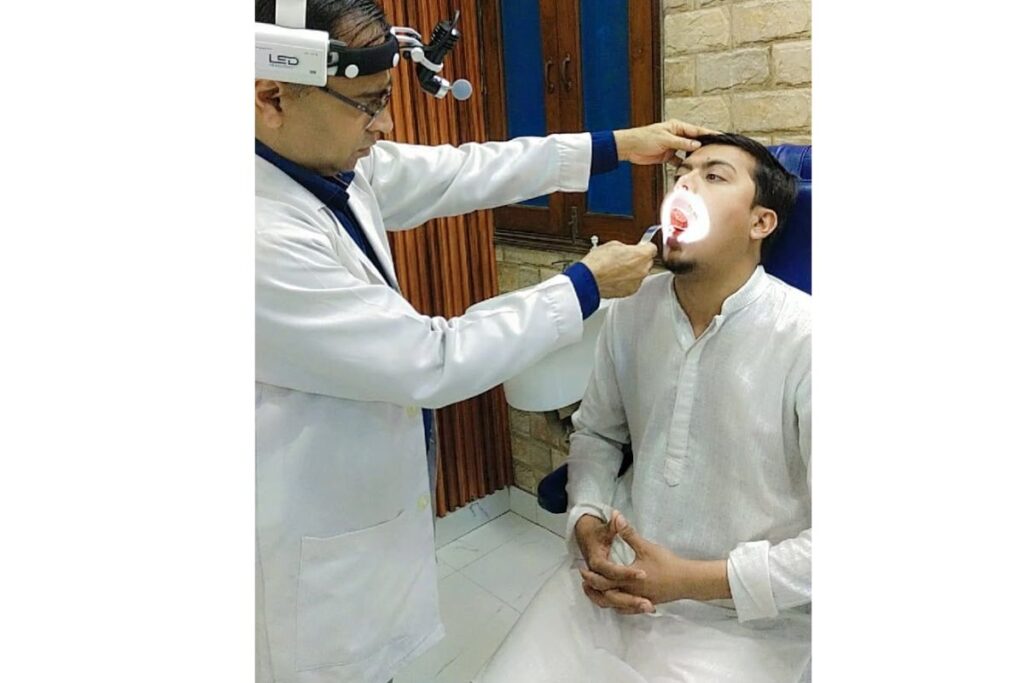 Dr Sanjay Gupta is checking the throat infection of a patient